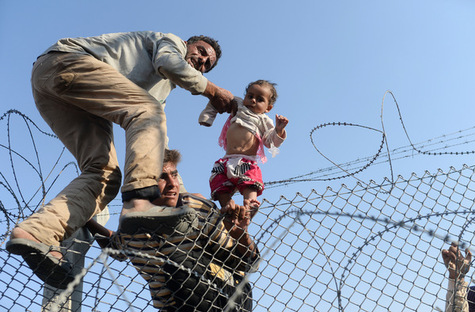 Des  syriens fuyant la guerre tentent de passer la frontiére turque à Akcakale, le 14 juin 2015. Bülent Kiliç/AFP